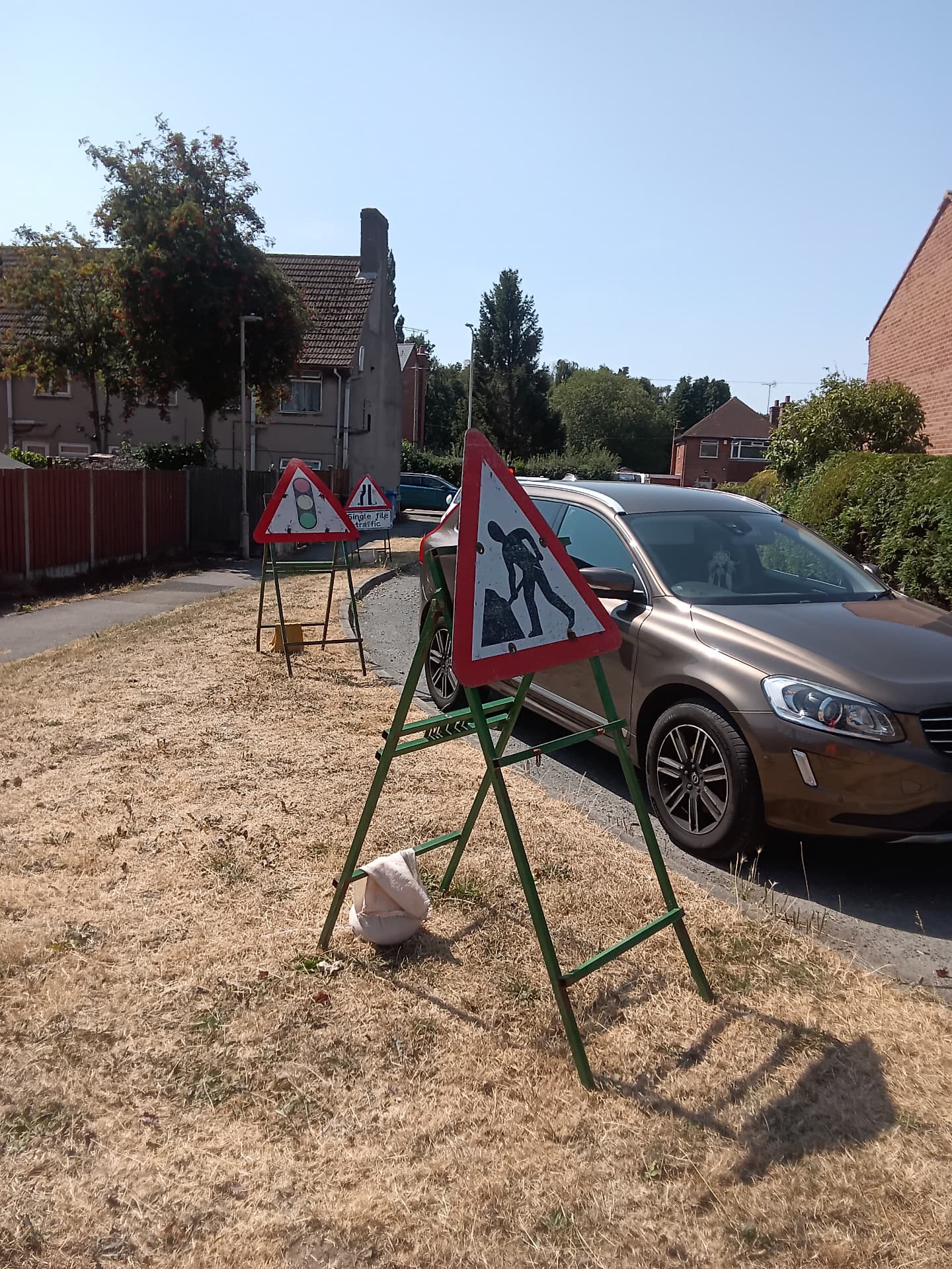 Roadworks signage and single file traffic setup on a residential street