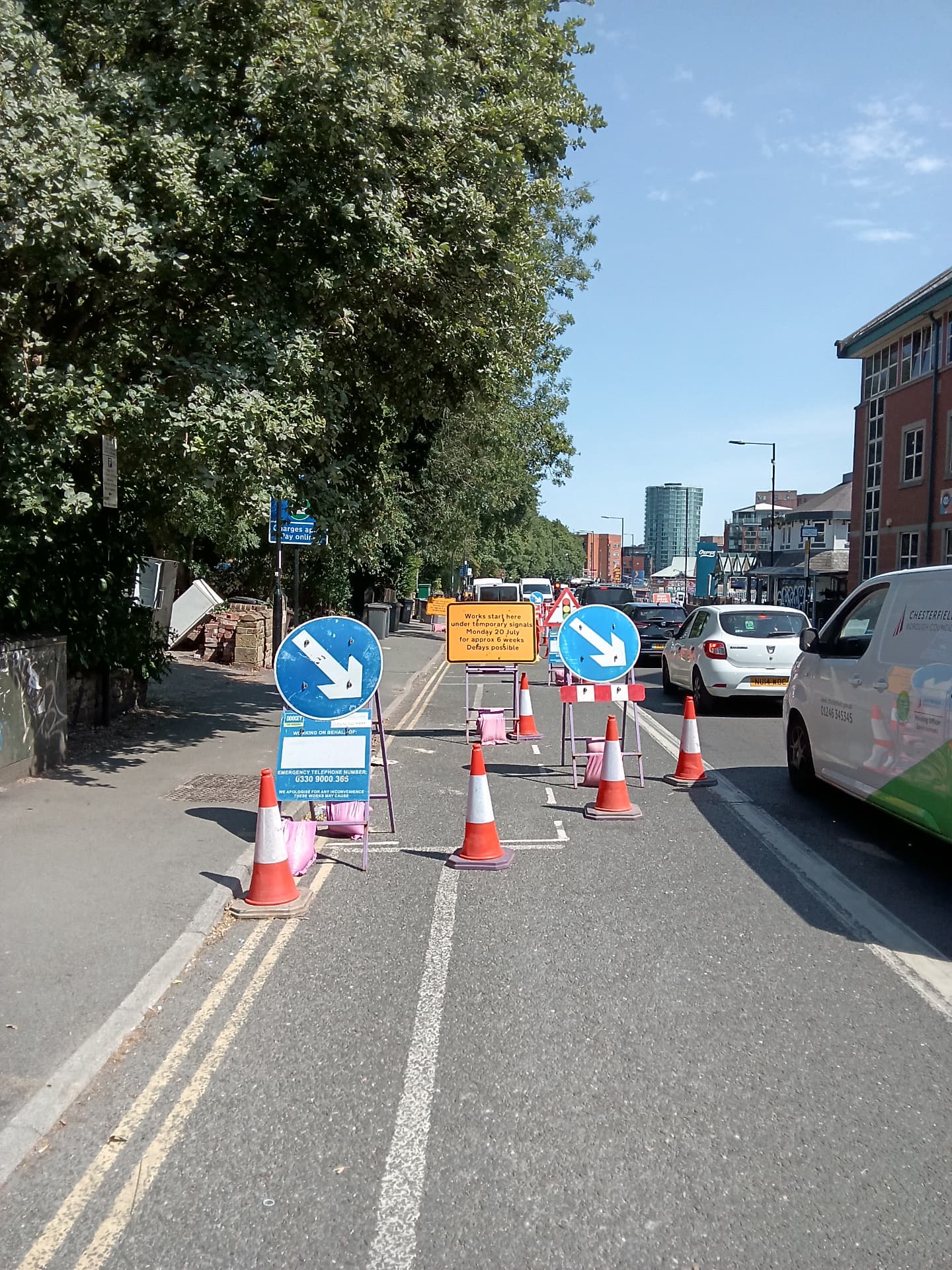 Temporary signal works and coned lane closure on a town centre road