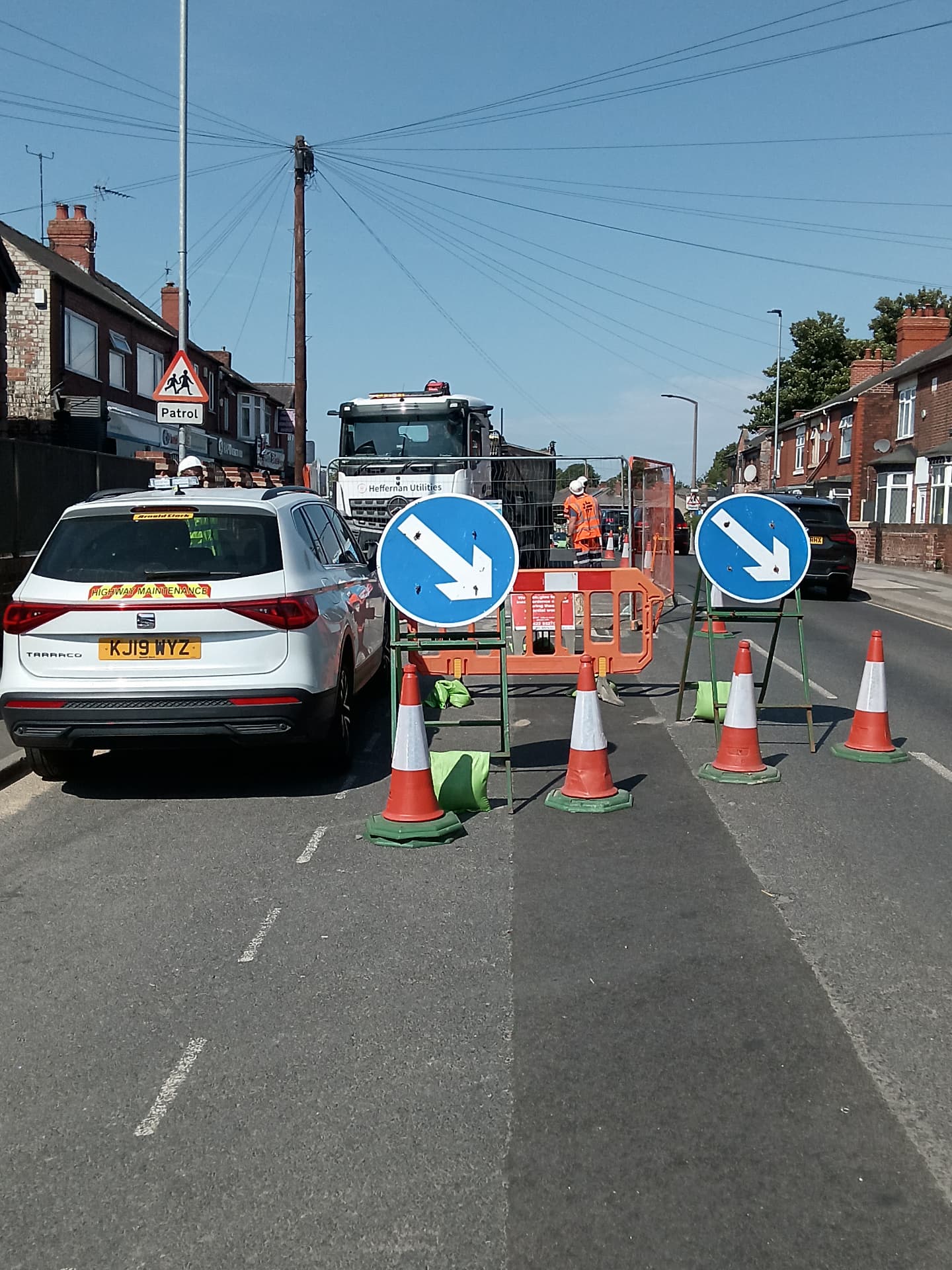 Highway maintenance crew working behind barriers on a residential street